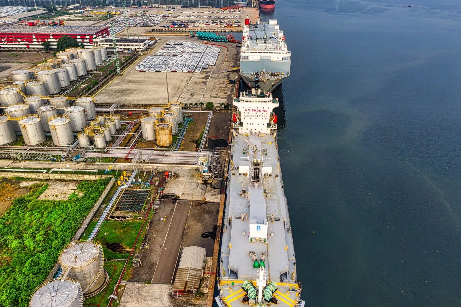 Aerial view of a fuel depot and tanker at an industrial port